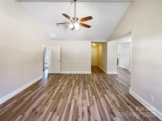 unfurnished living room with ceiling fan, high vaulted ceiling, wood finished floors, visible vents, and baseboards