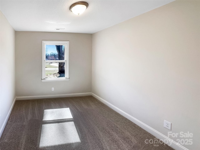 carpeted empty room featuring visible vents and baseboards