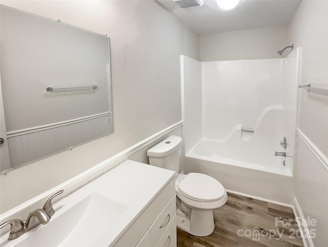 bathroom featuring vanity, shower / tub combination, wood finished floors, and toilet