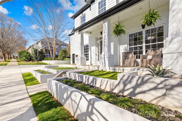 property entrance with brick siding and covered porch