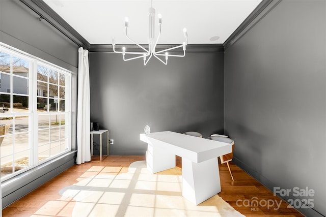 unfurnished dining area featuring a chandelier, light wood-type flooring, and ornamental molding