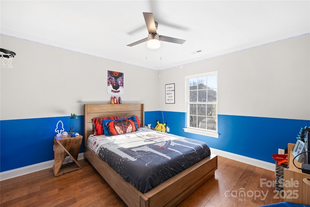 bedroom with ornamental molding, baseboards, and wood finished floors