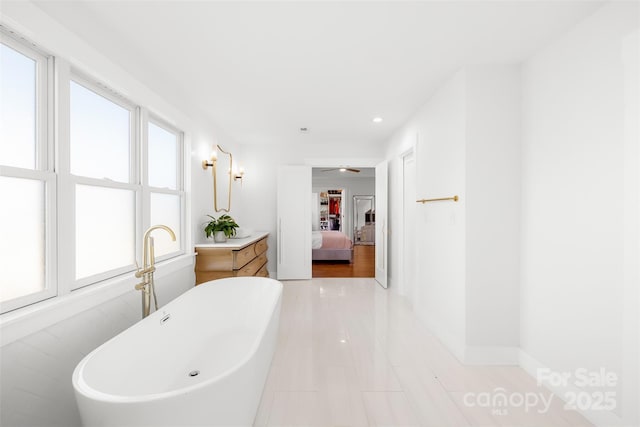 bathroom featuring a soaking tub, recessed lighting, and ensuite bathroom