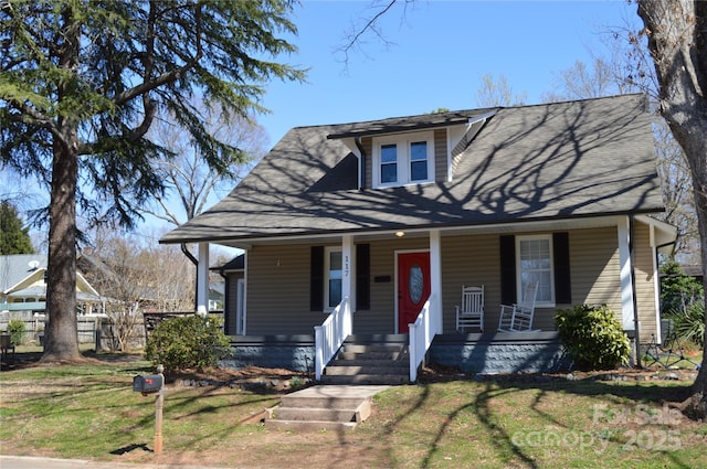 view of front of home with a front yard, fence, and covered porch