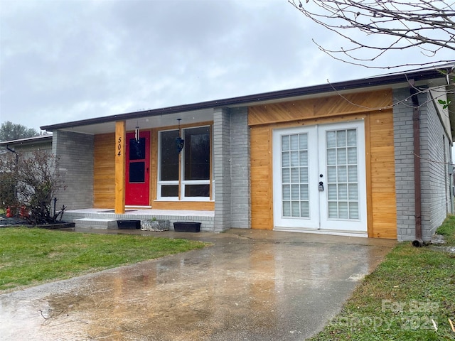 exterior space with brick siding and french doors