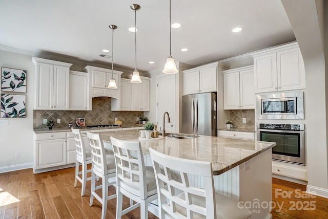 kitchen with light wood-type flooring, white cabinetry, and appliances with stainless steel finishes