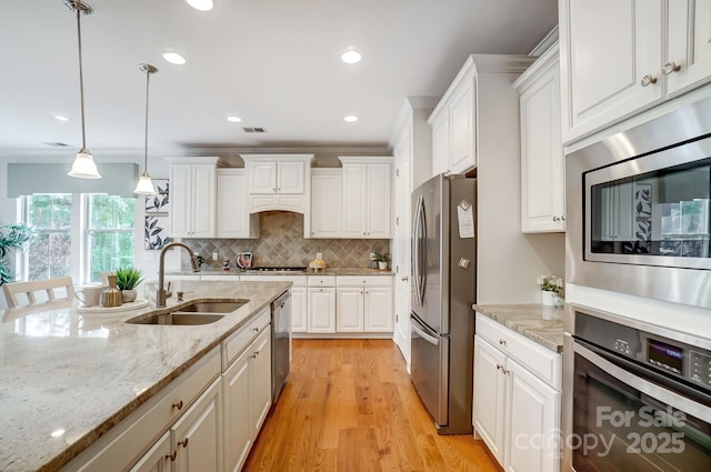 kitchen with stainless steel appliances, visible vents, a sink, and white cabinetry