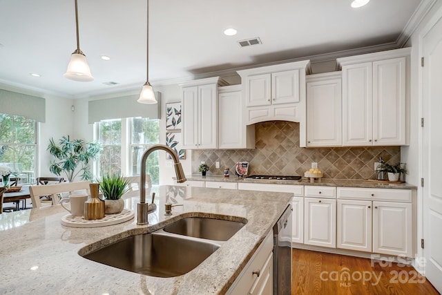 kitchen with a sink, visible vents, white cabinets, appliances with stainless steel finishes, and decorative light fixtures