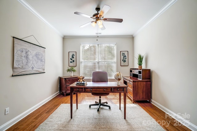 office space with ornamental molding, wood finished floors, a ceiling fan, and baseboards