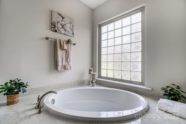 bathroom with a healthy amount of sunlight and a bath