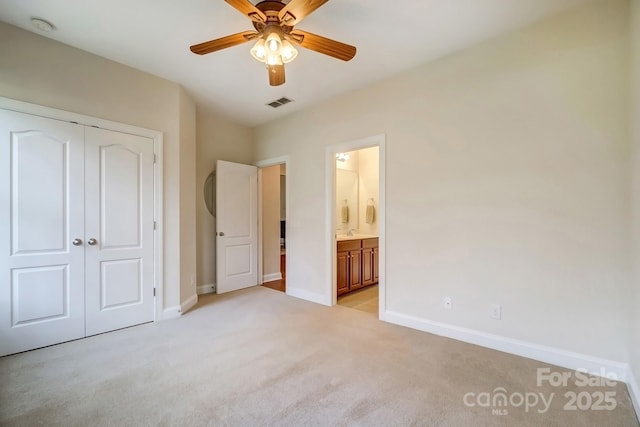 unfurnished bedroom with connected bathroom, light colored carpet, visible vents, baseboards, and a closet