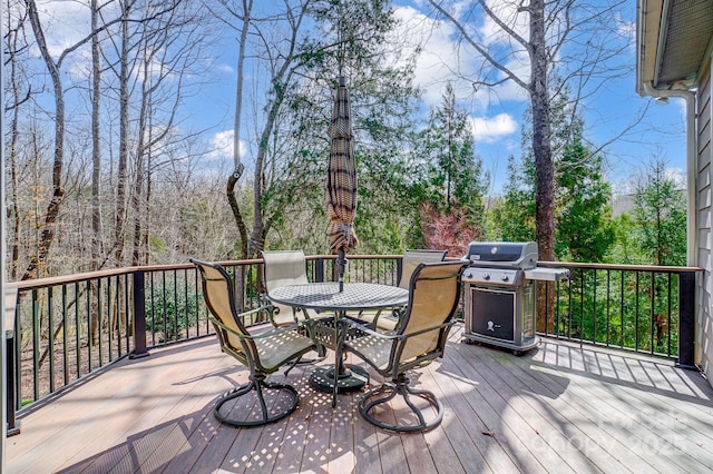 wooden terrace with outdoor dining space and a grill