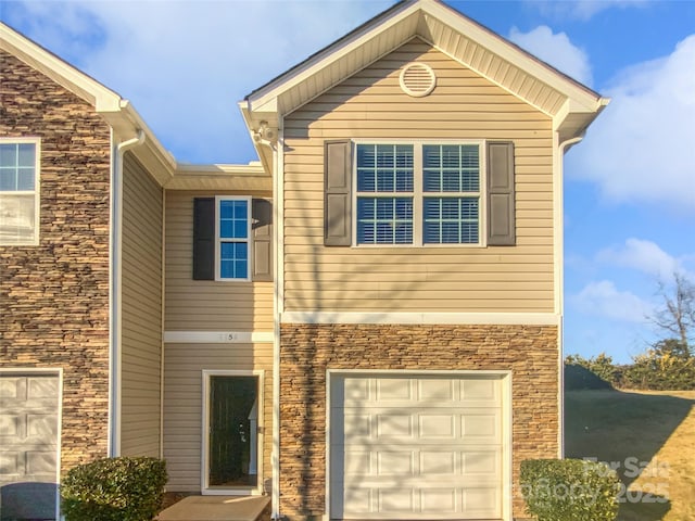 view of front of property featuring an attached garage and stone siding