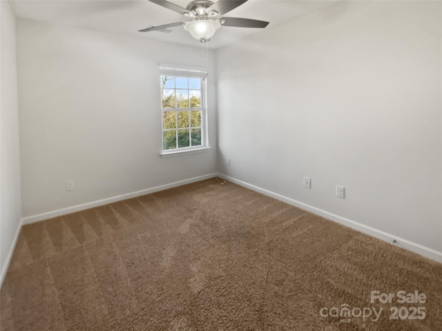 carpeted spare room with a ceiling fan and baseboards