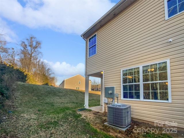 view of home's exterior with cooling unit and a yard