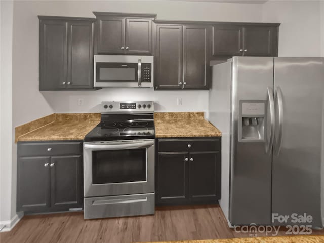 kitchen with appliances with stainless steel finishes and light wood-type flooring