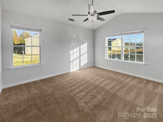 carpeted empty room with lofted ceiling, ceiling fan, visible vents, and baseboards