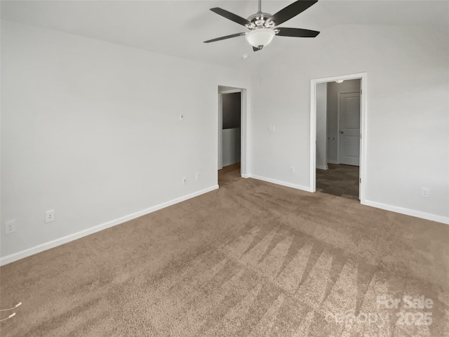 empty room featuring a ceiling fan, carpet flooring, vaulted ceiling, and baseboards