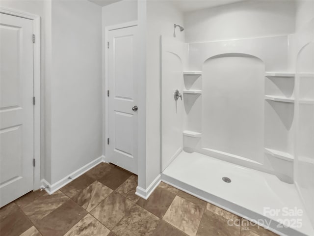 bathroom featuring baseboards and walk in shower