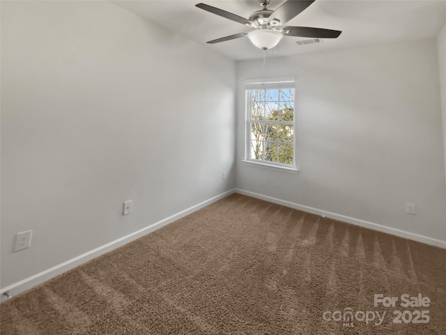 carpeted empty room with visible vents, ceiling fan, and baseboards