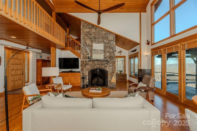 living area featuring a wealth of natural light, wood finished floors, wooden ceiling, and a fireplace