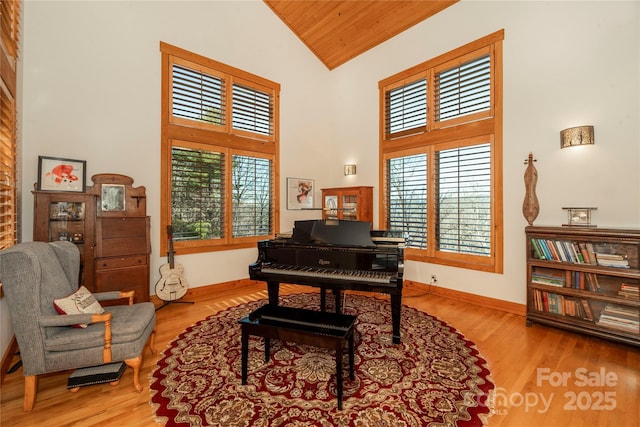 office space with baseboards, high vaulted ceiling, wood ceiling, and wood finished floors