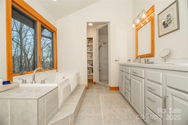 full bathroom featuring tile patterned flooring, walk in shower, a garden tub, lofted ceiling, and vanity