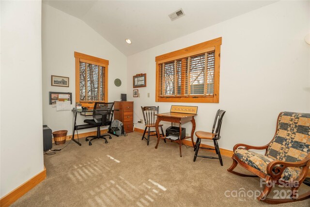 carpeted home office featuring lofted ceiling, baseboards, and visible vents