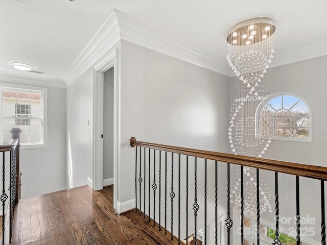 hall with an inviting chandelier, wood finished floors, crown molding, and an upstairs landing