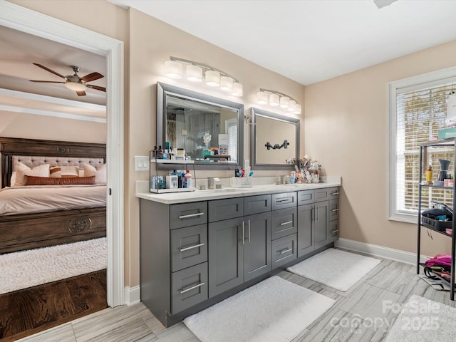 full bath featuring ceiling fan, vanity, baseboards, and ensuite bathroom