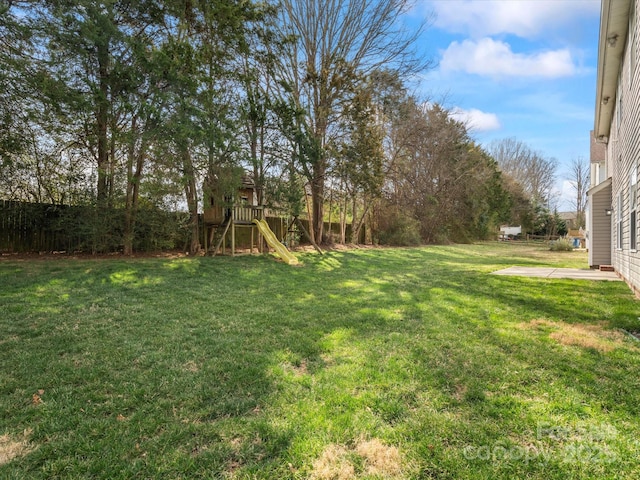 view of yard featuring a playground and fence