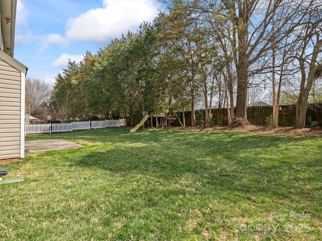 view of yard featuring a playground, a patio, and a fenced backyard