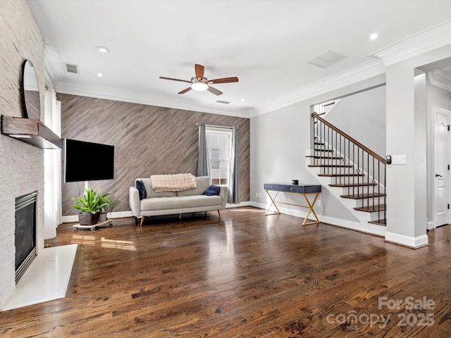 living area featuring ornamental molding, a fireplace, wood finished floors, and baseboards