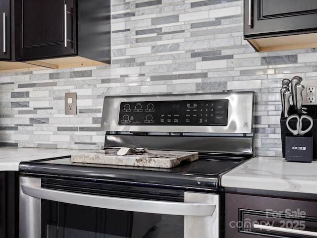 kitchen featuring light stone countertops, mail area, stainless steel electric stove, and decorative backsplash