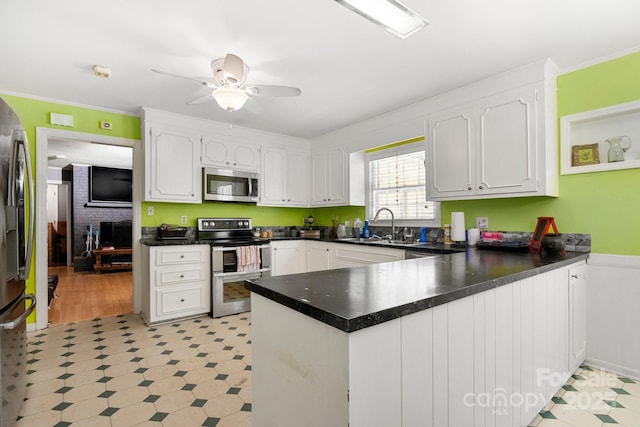 1210 Brookwood Dr, Shelby, NC 28150 - kitchen featuring appliances with stainless steel finishes, light flooring, a peninsula, white cabinetry, and ornamental molding