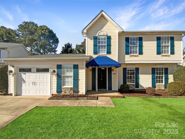 view of front of property featuring a front yard, concrete driveway, and an attached garage