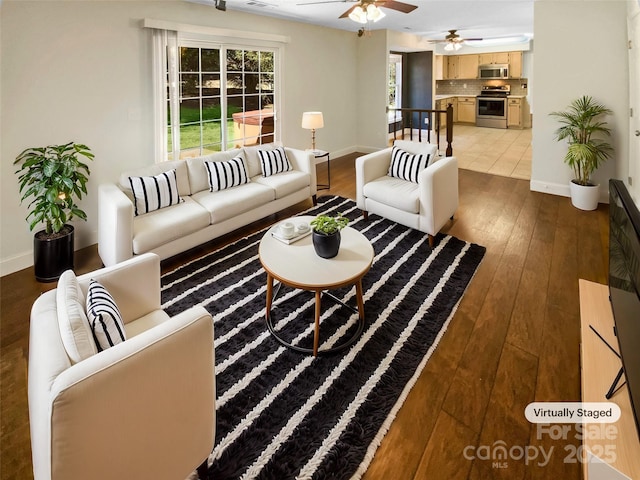 living room with wood-type flooring, baseboards, and ceiling fan