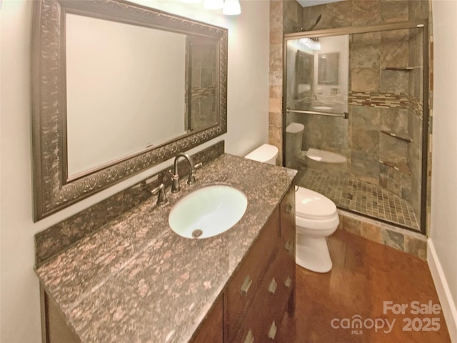 full bathroom with toilet, a shower stall, and vanity