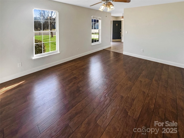 empty room featuring ceiling fan, plenty of natural light, hardwood / wood-style flooring, and baseboards