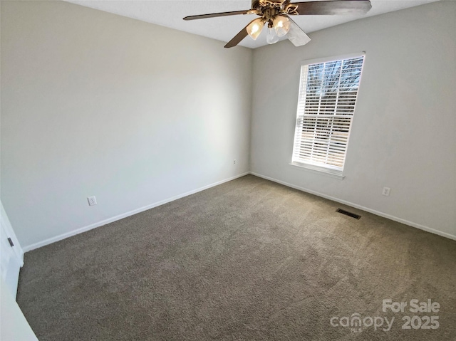 carpeted spare room with a ceiling fan, visible vents, and baseboards