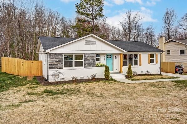 view of front of house featuring crawl space, fence, a front lawn, and board and batten siding