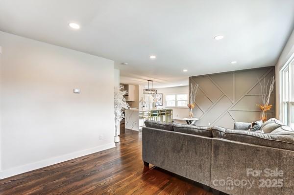 living area with recessed lighting, dark wood-style flooring, and baseboards