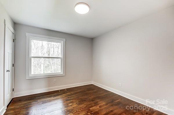 unfurnished room featuring dark wood finished floors and baseboards