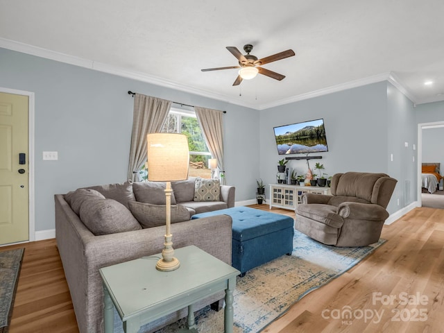 living room featuring crown molding, wood finished floors, and baseboards