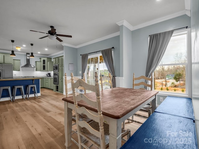 dining area with crown molding, recessed lighting, a ceiling fan, and light wood-type flooring