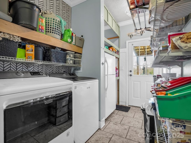 clothes washing area featuring crown molding, light tile patterned floors, laundry area, a textured ceiling, and separate washer and dryer