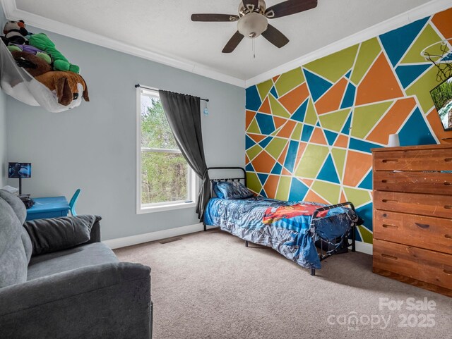 bedroom featuring an accent wall, crown molding, carpet flooring, and baseboards