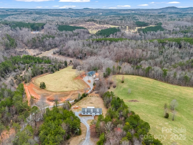 bird's eye view with a wooded view