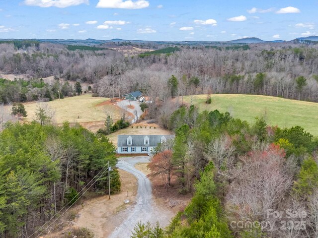 drone / aerial view featuring a mountain view and a wooded view