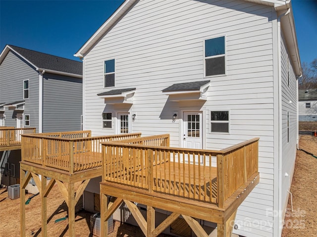 rear view of house with central air condition unit and a deck